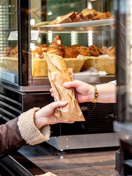 Customer receiving a pastry at Rosalie’s Snack & Go counter.